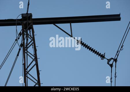 Eine Niedrigwinkelaufnahme einer Hochspannungsleitung unter einem hellblauen Himmel Stockfoto