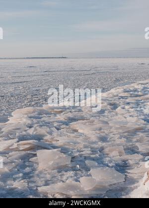 Winterlandschaft mit gefrorenem Eismeer und Leuchtturm auf einem Hintergrund Mangalsala riga 09.01.2024 Stockfoto
