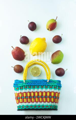 Gesundes Essen in einem Korb. Zero Waste Konzept, farbenfrohe wiederverwendbare Öko-Taschen. Mischung aus verschiedenen Früchten auf weißem Hintergrund, Einkaufspackung, Draufsicht, Stockfoto