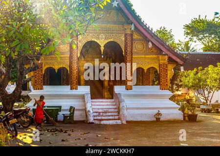 Ein junger Mönch (Samanera), der vor dem buddhistischen Tempel des Wat Sibounheuang in Luang Prabang, laos, reist Stockfoto