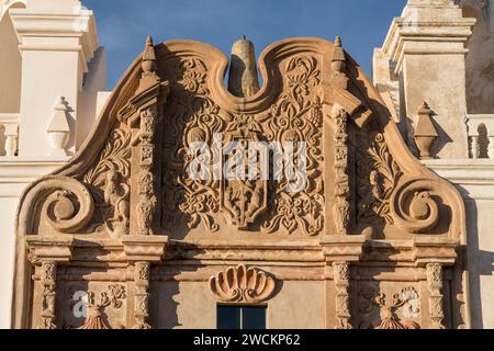 Geschnitztes Emblem des Franziskanerordens und Muschel der Pilgerfahrt an der Fassade der Mission San Xavier del Bac, Tucson Arizona. Stockfoto