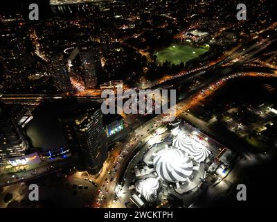 Eine belebte, von pulsierenden Lichtern beleuchtete Metropole, die bei Nacht im Verkehrslärm auftaucht Stockfoto