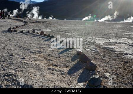 Dampf, der hinter Steinreihen vom Boden aufsteigt. Geysire Del Tatio, Antofagasta, Chile. Stockfoto