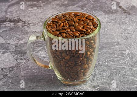 Glasbecher gefüllt mit Kaffeebohnen auf dem Tisch Stockfoto