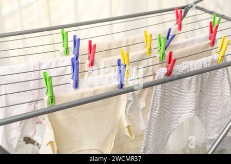 Saubere Babykleidung hängt am Trockner, Nahaufnahme Stockfoto