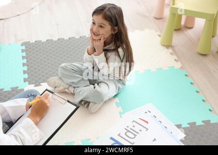 Kleines Mädchen, das einen Brief in der Praxis des Logopäden ausspricht Stockfoto