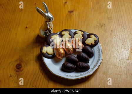 Süßigkeiten zu Ostern: Ostereier, Schokoladentaler mit Osterhasen auf einem Teller Stockfoto