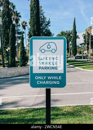 Budva, Montenegro - 17. august 2023: Schild an einer Stange im Park. Bildunterschrift: Parkplatz für elektrische Verkehrsmittel. Nur während des Ladevorgangs Stockfoto