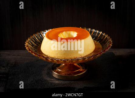 Cremiger Pudding aus Karamell auf dunklem Holzhintergrund. Stockfoto