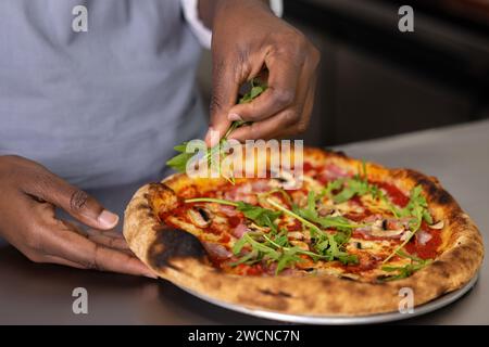 Nahaufnahme von Frauen, die Pizza schneiden Stockfoto