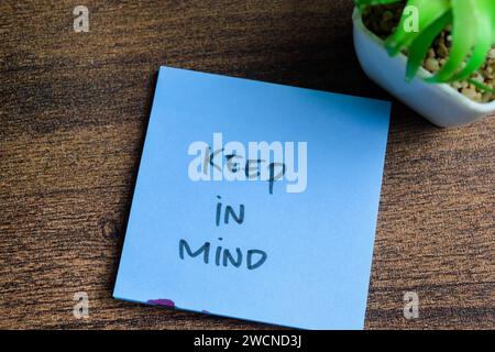 Konzept der im Auge behalten Schreiben Sie auf Haftnotizen isoliert auf Holztisch. Stockfoto