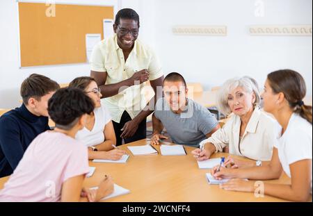 Multirassische gemischte Altersgruppe, die an der Erwachsenenbildungsklasse mit afroamerikanischem Tutor teilnimmt Stockfoto