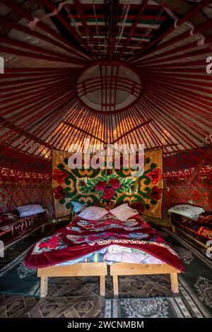 Traditionelle kirgisische Jurte für Übernachtungen für Touristen, mit vier Betten und Teppichen, Region Naryn, Kirgisistan Stockfoto