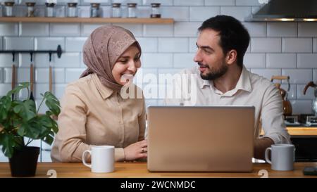 Ein Paar benutzte Laptop, um Nachrichten online zu lesen, empfing E-Mail Freude, die Gelegenheit zu Hause in der Küche zu feiern Stockfoto