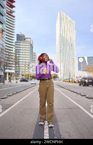 Urban Joy: Frau, die Musik auf der City Street genießt Stockfoto
