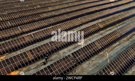 ZHANGYE, CHINA - 16. JANUAR 2024 - Arbeiter überprüfen den Betrieb der Photovoltaik-Stromerzeugung an der neuen Energiebasis in der Stadt Zhangye, Gansu p Stockfoto