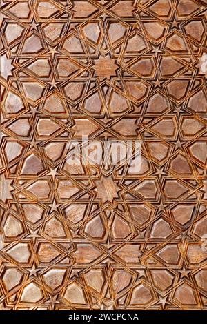 Geometrische Schnitzereien im islamischen Stil mit komplizierten Sternformen aus einer Tür einer Moschee, traditionelles handgefertigtes orientalisches Architekturfragment bac Stockfoto