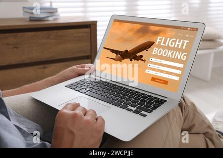 Mann mit Laptop, um zu Hause Flug zu buchen, Nahaufnahme Stockfoto