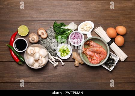 Kochen Sie köstliche Ramen-Suppe. Verschiedene Zutaten auf Holztisch, flache Ladefläche Stockfoto