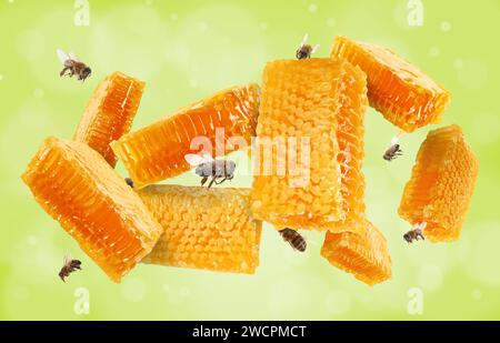 Wabenstücke in der Luft und Bienen fliegen auf gelblichem grünem Hintergrund, Bokeh-Effekt Stockfoto