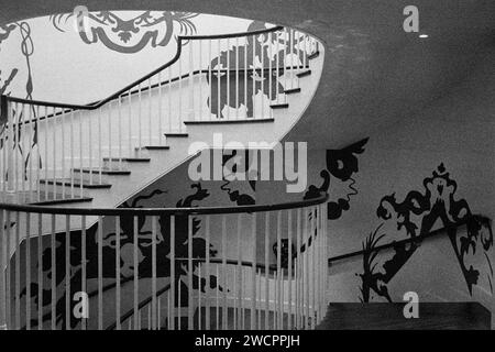 Dezember 2023 - Peabody Essex Museum - Salem, Massachusetts. Eine runde Treppe mit hochgestalteter grafischer Tapete aus der Mitte des Jahrhunderts an den Wänden. Bild war c Stockfoto