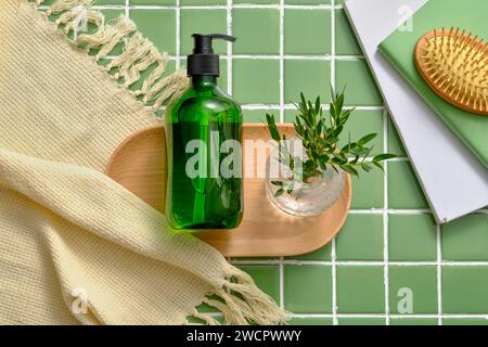 Ein Holztablett mit Pumpflaschenspender ohne Marke und eine Glasvase mit grünen Blättern. Leeres Etikett für Shampoo oder Conditioner Haarpflege-Mock Stockfoto