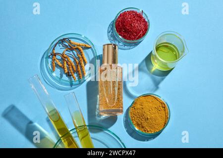 Eine Tropfflasche ohne Etikett mit Petrischalen aus Safran, Cordyceps Pulver und Cordyceps Sinensis. Becher und Reagenzgläser gefüllt mit Yello Stockfoto