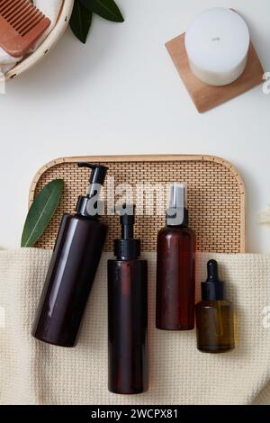 Verschiedene Arten von Kosmetikbehältern sind auf einem Bambustablett dekoriert. Leerzeichen für Text auf weißem Hintergrund. Leeres Etikett für kosmetische Produkte Stockfoto