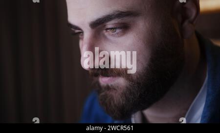 Nahaufnahme eines jungen Geschäftsmannes, der nachts am Computer arbeitet. Fokussierter Mann, der auf der Laptop-Tastatur schreibt, erledigt die Arbeit Stockfoto