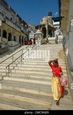 Pushkar, Indien - 4. Januar 2024: Eine Frau, die entlang eines Ghetts des Pushkar Lake in Rajasthan, Indien, spaziert. Stockfoto