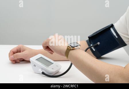 Mann mittleren Alters, der Blutdruck auf Smartwatch eingibt. Digitales Gesundheitskonzept Stockfoto