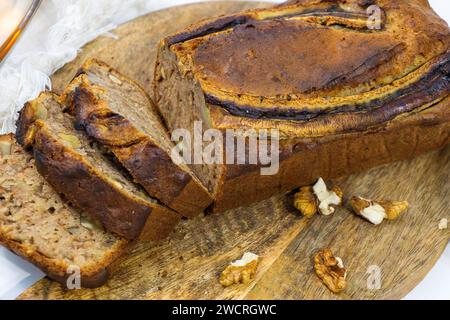 Hausgemachtes Bananenbrot auf verwundetem Schneidebrett. Stockfoto