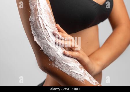 Junge Frau, die pflegende Creme-Lotion aufträgt Stockfoto