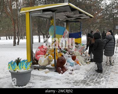 Nicht exklusiv: DNIPRO, UKRAINE - 14. JANUAR 2024 - Mitglieder der Öffentlichkeit wohnen an der Haltestelle, die als Gedenkstätte für 46 Menschen dient, darunter 6 Kinder, Stockfoto