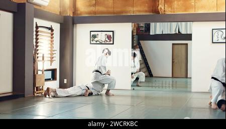 Studenten, Karate oder Leute, die im Dojo für Fitness, Kampfkunst oder Selbstverteidigung lernen. Demonstration, Workout oder Kung Fu Master Stockfoto