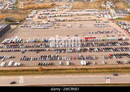 Drohnenfotografie eines großen Parkplatzes mit geparkten Autos am sonnigen Herbstmorgen Stockfoto