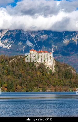 Eine atemberaubende Landschaft mit majestätischen Bergen in der Ferne, mit einem malerischen Schloss auf einer Klippe über dem See in Bled, Slowenien Stockfoto