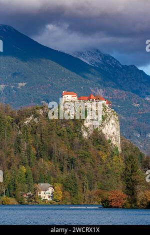 Eine atemberaubende Landschaft mit majestätischen Bergen in der Ferne, mit einem malerischen Schloss auf einer Klippe über dem See in Bled, Slowenien Stockfoto