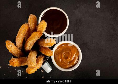 Zuckersüße Churros mit Dulce de leche und Schokolade. Stockfoto