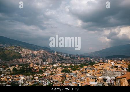 Ein Panoramablick auf eine dicht besiedelte Stadt, die sich über hügeliges Gelände erstreckt, im Kontrast zu einem dramatischen bewölkten Himmel Stockfoto
