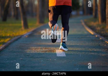 Blick von der Rückseite der Füße des Läufers mit Sportschuhen, die im Park laufen Stockfoto