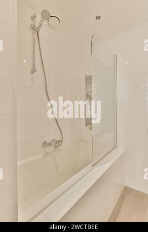 Ein elegantes, modernes Badezimmer mit sauberer Badewanne, Glasduschtrennwand und minimalistischen Armaturen. Stockfoto
