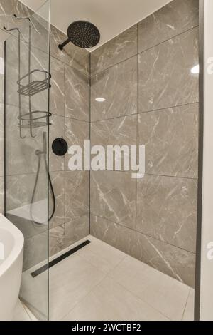Modernes Bad mit Marmorfliesen, bodenebener Glasdusche und eleganten schwarzen Armaturen. Stockfoto