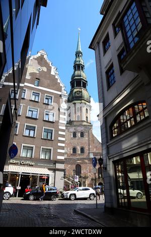 Ein Ensemble aus neuen und alten Gebäuden in den Straßen von Riga. Glockenturm von St. Petersdom. Reflexion von Altbauten in Glasfassaden Stockfoto