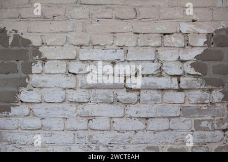 Fragment der alten Ziegelwand mit weißem Stuck Stockfoto