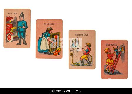 Alte Retro-glückliche Familien spielen Karten isoliert auf weißem Hintergrund - die Blaze-Familie, Mr Blaze der Feuerwehrmann mit Frau, Sohn und Tochter - Großbritannien Stockfoto