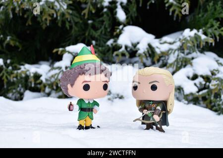 Funko Pop Actionfiguren von Buddy aus dem Comedy-Film Elf und Legolas aus dem Fantasy-Film der Herr der Ringe. Winterwald, Schneewehungen, grüne Wälder. Stockfoto