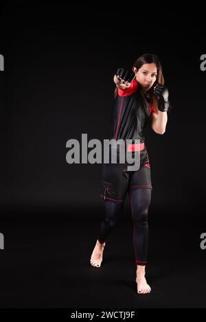 Die kaukasische MMA-Kämpferin führt einen mächtigen Schlag aus und zeigt in jeder Bewegung ihr Engagement, ihre Entschlossenheit und ihren Ernst. Ihr entschlossener Ansatz und Stockfoto