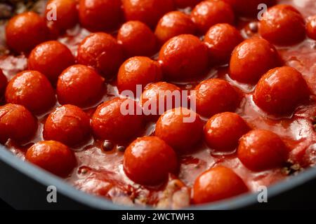 Augsburg, Bayern, Deutschland - 13. Januar 2024: Kirschtomaten in Tomatensoße gekocht *** Cherrytomaten kochen in einer Tomatensoße Stockfoto