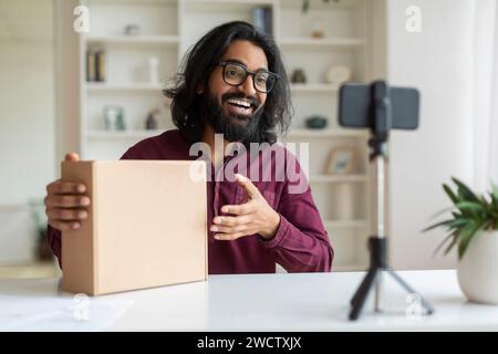 Indischer Influencer Guy trägt Brille und macht Videorezension des Produkts vor der Kamera Stockfoto